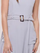 Vestido midi blanco de la marca Nina Leonard, sin mangas y con escote cuadrado. Cuenta con corte en la cintura, bolsillos laterales con solapa, falda fluida con detalle de frunce inferior e incluye un cinturón del mismo género con hebilla carey.