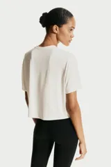 Remera deportiva de corte boxy y holgado, confeccionada en tejido funcional con tecnología DryMove que absorbe el sudor. Presenta cuello redondo, mangas cortas con hombros caídos y bajo recto.