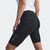Short de compresión de tiro medio para mujer, color negro, con estampado texturizado y el logo grande de 2XU en amarillo dorado en el muslo izquierdo.