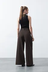 Pantalón wide leg negro de tiro alto con caída fluida y silueta amplia. Presenta cintura alta con botonadura frontal visible.