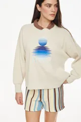 Sweater de punto color amarillo con diseño relajado y escote redondo, confeccionado en mezcla de algodón y acrílico. Presenta un bordado frontal con motivo de sol y reflejos acompañado de la inscripción "Petra".