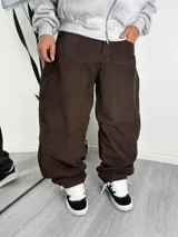Pantalón de corte baggy confeccionado en pana color marrón, con diseño de tiro medio y ajuste holgado en las piernas.