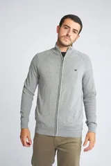 Campera tejida de algodón con cierre frontal completo, cuello alto y mangas largas. Presenta un diseño básico con logo bordado en el pecho.