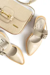 Zapato de tacón cuadrado y plataforma, color beige, con punta cerrada y tira ajustable con hebilla metálica en el tobillo.