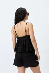 Top blanco con breteles finos y detalle de encaje en el escote.