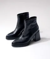 Bota corta de cuero negro con diseño combinado, presentando una textura lisa en la parte frontal y una textura tipo reptil en el talón. Cuenta con taco cuadrado alto, plataforma delantera y cierre lateral interno.