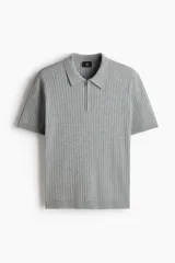 Remera polo de punto acanalado fino, con cuello clásico, medio cierre frontal y mangas cortas. Presenta un diseño entallado con bajo recto.