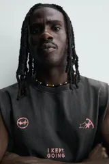 Musculosa de corte relajado con efecto lavado, cuello redondo y sisas amplias. Presenta estampados gráficos en color rosa en el frente con la frase 'I KEPT GOING'.