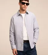Camisa de vestir masculina de manga larga, confeccionada en tricolina con un sutil estampado de cuadros grid. Presenta cuello clásico, abotonadura frontal y puños con botones.