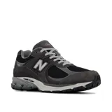Championes urbanos New Balance modelo 2002R, color gris oscuro con detalles en negro. Confeccionados en una combinación de gamuza y malla, cuentan con el logo N en los laterales, tecnología N-ergy en la entresuela y cordones grises.