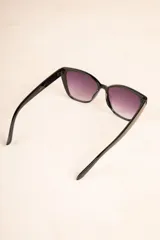 Lentes de sol negros con forma de ojo de gato y cristales degradados.