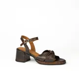 Sandalias de cuero color dorado, con plataforma y taco cuadrado. Presentan tiras cruzadas en el empeine y pulsera al tobillo con hebilla.