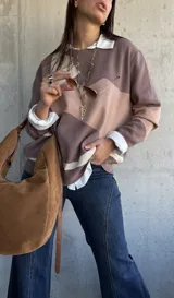 Sweater de punto con diseño de bloques de color en tonos tierra y beige, de corte oversize, cuello redondo y manga larga.