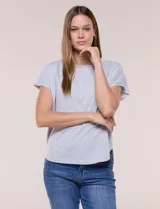 Remera de silueta amplia y relajada de color gris melange, confeccionada en algodón con poliéster. Presenta escote a la base con terminación rústica de borde enrollado, mangas cortas de hombro caído sin dobladillo y ruedo curvo con la parte posterior más larga.