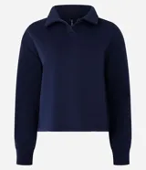 Buzo de algodón con interior afelpado, color azul marino, con cuello polo y mangas largas con puños elásticos.