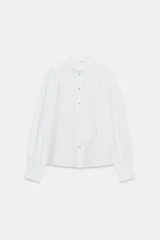 Camisa de algodón color blanco, de manga larga con puños anchos, cuello alto con detalle de pañuelo incorporado y cierre frontal con botones joya dorados.