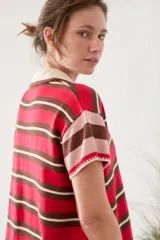 Vestido tipo polo corto tejido de punto, con diseño de rayas horizontales en tonos rojo, marrón y blanco, cuello y escote V en color tostado, y mangas cortas holgadas.