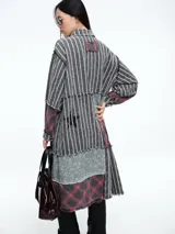 Camisa larga de diseño patchwork con cierre frontal de botones, confeccionada mediante la combinación de paneles con estampados de rayas, cuadros escoceses y motivos florales, con terminaciones deshilachadas.