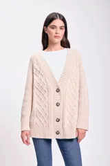 Saco de punto abierto con botones frontales, cuello en V y diseño de trenzas en relieve. Presenta puños y ruedo acanalados.