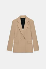 Blazer de corte estructurado en color beige, con cuello de solapa, cierre frontal cruzado con botones y bolsillos con solapa en el delantero.