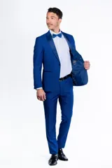 Ambo de fiesta Florenzi modelo Selvino, color azul vibrante con textura sutil. El saco presenta solapas en punta de raso, cierre de un botón forrado y abertura trasera. El pantalón es de corte slim fit.