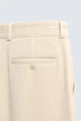 Pantalón de corte wide fit confeccionado en pana de algodón color marrón oscuro. Presenta bolsillos frontales, bolsillos traseros de vivo con botón y cierre frontal con cremallera y botón.