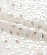 Remera de algodón color blanco con cuello redondo y mangas cortas. Presenta un estampado de lentejuelas con efecto de lluvia en el frente.