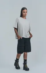 Bermuda de denim negra, estilo cargo, con calce oversize. Presenta múltiples bolsillos con tapa en los laterales y un ligero efecto de desgaste.
