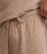 Conjunto de pijama para hombre, compuesto por una remera de manga corta con cuello redondo y un short con cintura elástica y cordón de ajuste. El tejido es de malla flamê con efecto mezcla en tonos beige y marrón.