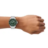 Reloj analógico Emporio Armani World Explorer con caja de acero inoxidable de 42mm, esfera color verde con tecnología solar y pulsera de eslabones de acero plateado. Cuenta con bisel giratorio, índices luminiscentes y resistencia al agua de 100 metros.
