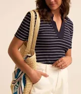 Blusa de ribana azul marino con rayas horizontales blancas, cuello polo en pico y mangas cortas.