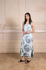 Vestido largo de seda color amarillo con estampado batik en tonos verde oliva y blanco. Escote en V con ribete de punto fino en cuello y mangas. Talle único.