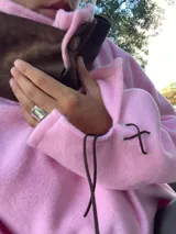Sweater de tejido de punto suave en color rosado, con diseño holgado, cuello redondo y aberturas laterales en el ruedo.