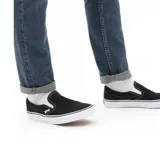 Championes Vans Classic Slip-On negros con suela blanca.