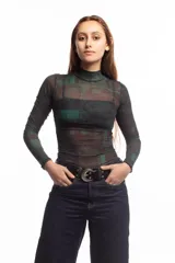 Top de manga larga con cuello alto, confeccionado en tejido de malla semitransparente con estampado gráfico abstracto en tonos verdes y negros.