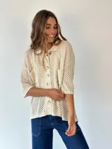 Camisa de punto calado color pistacho con hilos de lurex. Posee cuello camisero, botones frontales, mangas cortas y bolsillos delanteros.