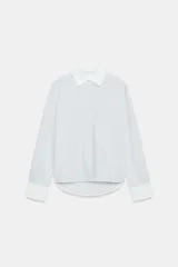 Camisa de algodón con estampado de rayas verticales, cuello solapa y puños en color blanco a contraste. Presenta cierre frontal con botones, bolsillo de plastrón en el delantero y bajo asimétrico.