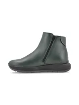 Bota corta de cuero color verde oscuro, con cierre lateral y suela de goma negra tipo plataforma.