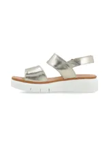 Sandalia de cuero metalizado color dorado con dos tiras de ajuste con velcro y plataforma baja de poliuretano blanco.