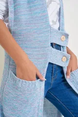 Chaleco largo de hilo y algodón melange con flecos, con bolsillos y dos presillas para botones.