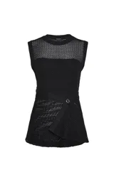 Musculosa de punto negro Le Lis Blanc, de corte recto, escote redondo, sisas amplias y tejido calado con transparencia. Presenta un diseño asimétrico con superposición frontal y detalle de anillo metálico en el lateral.
