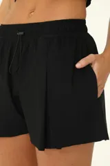 Short deportivo negro con diseño de falda con tablas encontradas en el frente y bolsillos laterales.