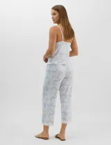 Conjunto de pijama de tres piezas en color celeste con estampado floral blanco y detalles de puntilla de encaje. Incluye una musculosa de breteles finos con escote en V, un capri con cintura elástica y cordón ajustable, y una camisa a juego.