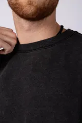 Remeron de algodón rústico con efecto de lavado gastado, corte oversize, cuello redondo y mangas cortas con terminaciones al corte.