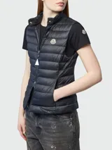 Chaleco puffer Moncler modelo Igens, de color negro con diseño acolchado horizontal, cierre frontal con cremallera y bolsillos laterales. Presenta cuello alto y el parche con el logotipo de la marca en el pecho.