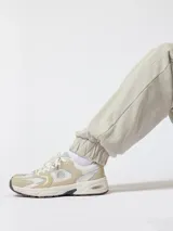 Pantalón jogger de corte holgado color beige, con cintura elástica, amplios bolsillos laterales y puños ajustados con goma.
