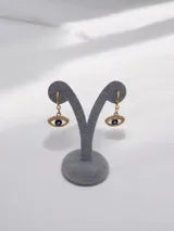 Caravanas tipo argolla con dije colgante en forma de ojo turco con pestañas doradas.