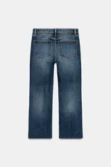 Jeans de tiro alto con diseño de cinco bolsillos y corte cropped flare. Presenta un acabado deshilachado en el bajo y cierre frontal con cremallera y botón metálico.