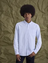 Camisa de manga larga confeccionada en tejido Oxford de algodón, con cuello abotonado (button-down) y bolsillo frontal en el pecho.