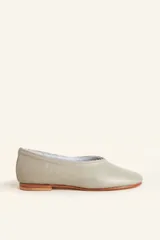 Ballerinas de cuero vacuno en color gris, con diseño de punta redondeada, suela plana de madera y detalle de borde trenzado a mano.